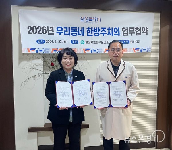 유종우 효행구보건소장과 명한의원 윤탁현 원장이 업무협약을 체결하고 협약서를 들고 기념촬영을 하고 있다