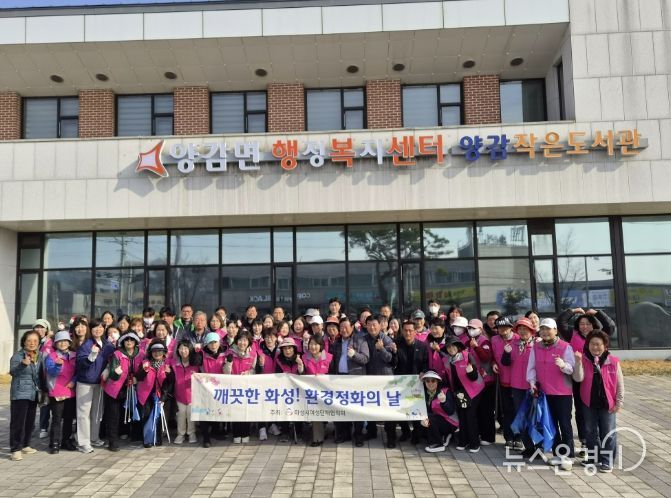 화성시여성단체협의회와 관계자들이 양감면 환경 정화 활동을 기념하고 있다