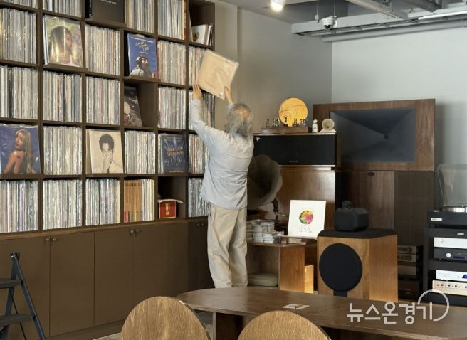 음악감상실 온 주인장이 신청곡 LP를 찾고 있다.